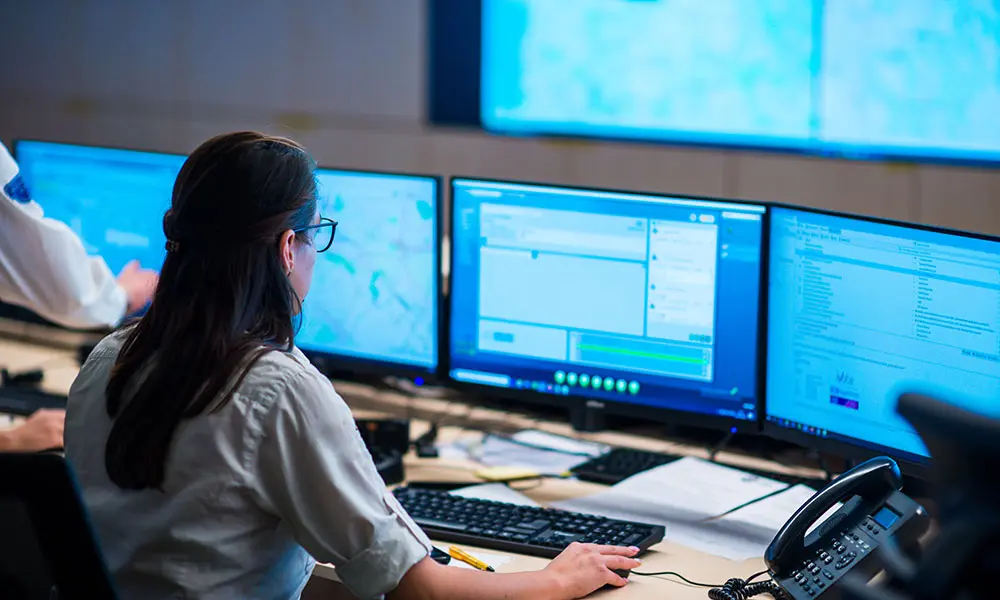 Security control room with operators monitoring alarm systems